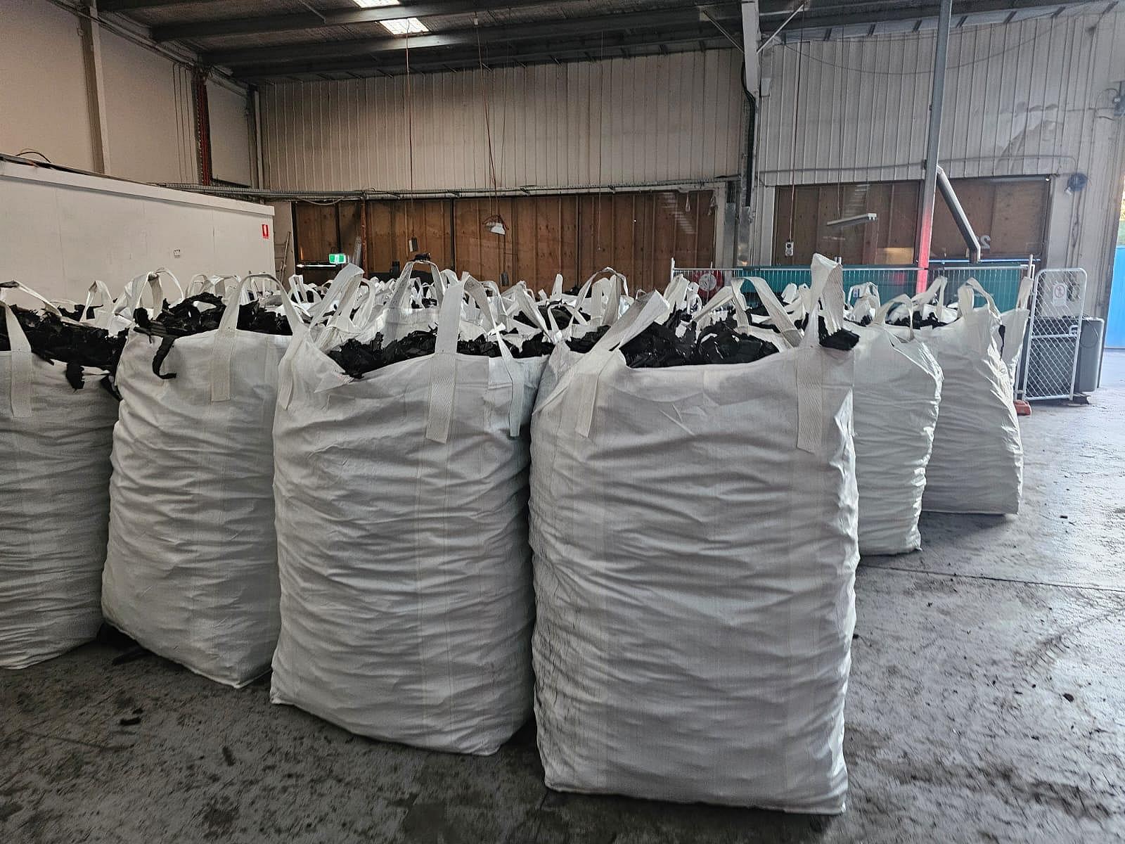 Pressed bales and big bags on a handling yard, ready for loading
