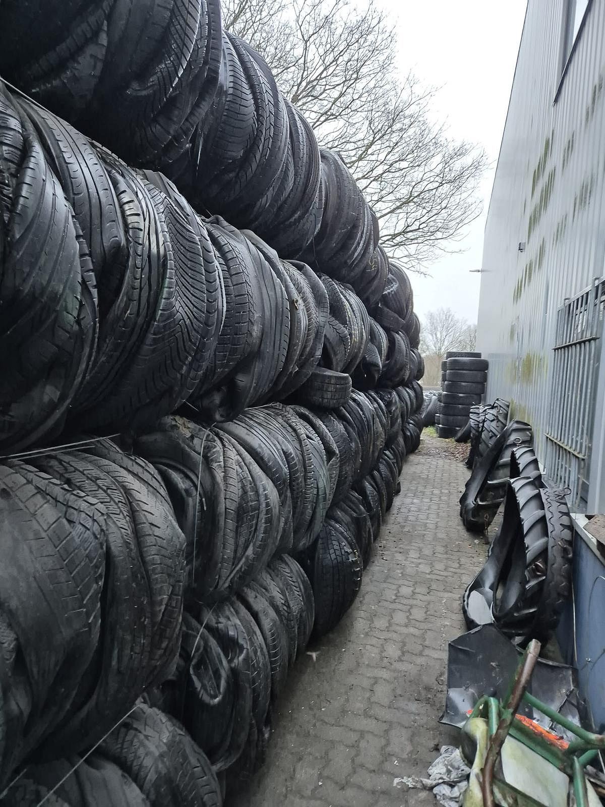 Stacked bales of end-of-life tyres in a warehouse, ready for loading