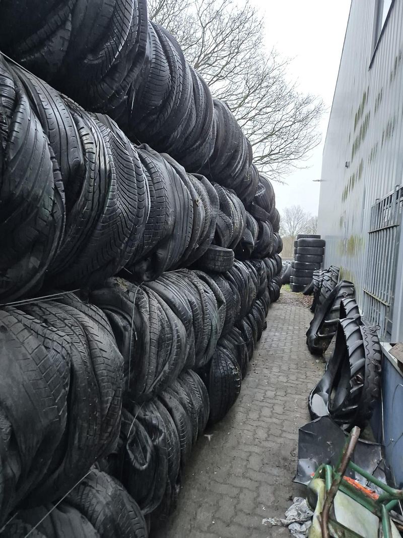 Stacked bales of end-of-life tyres in a warehouse, ready for loading