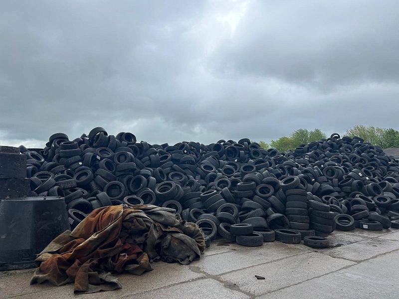 Sorted end-of-life tyres in a covered store before processing